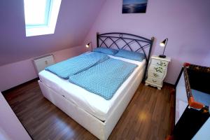 多尔努姆Ferienwohnung Sonne&Meer的一间卧室配有一张带蓝色床单的床和一扇窗户。