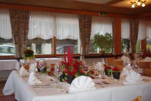 锡格里斯维尔阿德勒酒店的用餐室配有白色的桌子和鲜花