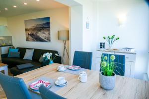库克斯港Am Sahlenburger Strand AS01的客厅配有木桌和蓝色椅子