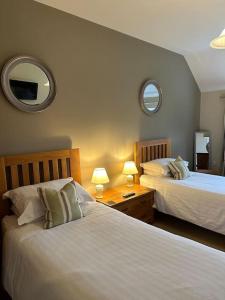 奇平卡姆登Groves Barn at Norton Grounds的酒店客房带两张床和两面镜子