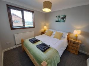 BrundallRiver Retreat - Norfolk Broads的一间卧室配有一张床,上面有两条毛巾