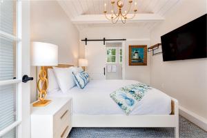 楠塔基特Nantucket Resort Collection的一间白色卧室,配有床和电视