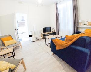 蒙吕松Artbleu -Tout Confort - Idéal Pros - Proche commerces的客厅配有蓝色的沙发和电视