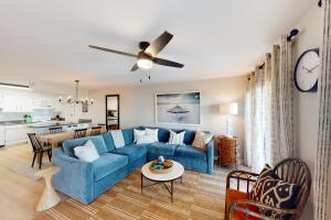 奥兰治比奇Cotton Bayou B1的一间带蓝色沙发的客厅和一间厨房