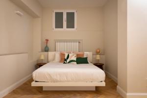 米兰Castore Apartment的卧室配有白色的床和两张桌子