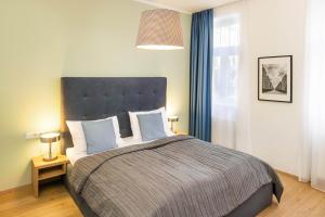 维也纳Jimmy's Apartments Dandelion的一间卧室配有一张带蓝色窗帘的大床