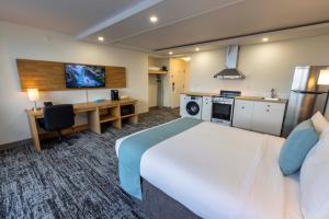 鲁珀特王子港Highliner Hotel的酒店客房设有一张大床和一张书桌。