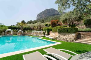 阿拉罗Hotel Rural S'Olivaret & Spa的一个带椅子的游泳池,后方是一座山。