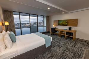 鲁珀特王子港Highliner Hotel的配有一张床和一张书桌的酒店客房