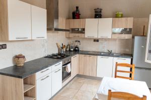 Grand-PopoSpacious and cozy beachfront villa的厨房配有白色橱柜和炉灶烤箱。
