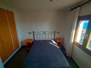 卡拉德莫尔Habitacion en casa particular con vista al mar的一间卧室配有一张带两张桌子和一扇窗户的床。