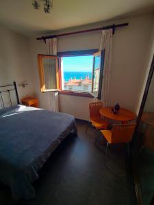 卡拉德莫尔Habitacion en casa particular con vista al mar的一间卧室配有一张床、一张桌子和一个窗户。