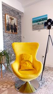 马拉加Casa Princesa Huelin的一张黄色椅子,上面有一个枕头,放在一个房间里