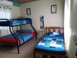圣卡塔利娜岛Oceans Hostal的一间卧室设有两张双层床和一张桌子