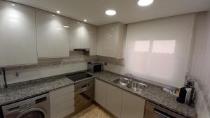 马尔格莱特德玛Atico duplex en Malgrat de Mar的厨房配有白色橱柜和水槽
