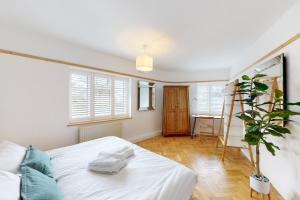 基尤Stunning 2 bed flat in Richmond的卧室配有白色的床和植物