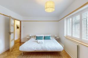基尤Stunning 2 bed flat in Richmond的一间卧室配有带白色床单和蓝色枕头的床。