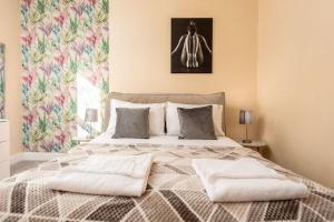普雷斯蒂克Briarhill - Donnini Apartments的一间卧室配有一张大床和两个枕头