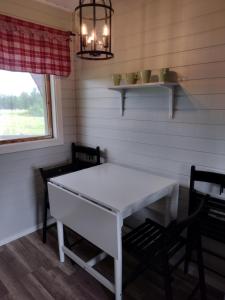 耶利瓦勒Piilijärvi Camping的一间配备有白色桌子和两把椅子的用餐室