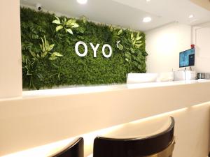 首尔OYO Hostel Myeongdong 5的带有绿色墙的办公室,带有oo标志