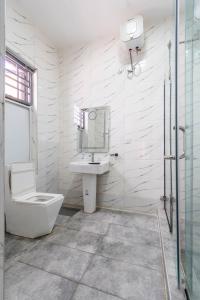 莱基Cecilia Homes的白色的浴室设有水槽和卫生间。