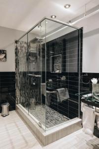 蒙特利尔Lofts du Vieux-Port by Gray Collection的浴室设有玻璃淋浴间,铺有黑色瓷砖