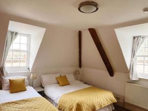 特罗布里奇4 bed loft apartment overlooking historic town的带2扇窗户的客房内的2张床