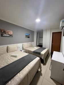 卡宁德圣弗朗西斯科POUSADA CECILIA的酒店客房,设有两张床和一张沙发