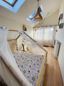 Plancher-BasLe Nid Douillet的一间带一张床铺的卧室,位于带天花板的房间内