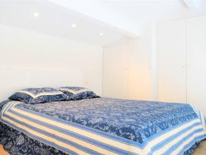 勒拉旺杜Appartement Cavalière, 1 pièce, 5 personnes - FR-1-251-456的一间卧室配有一张带蓝色棉被和枕头的床