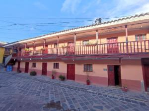 库斯科Anais y Nicolas Hostel Cusco的一座带红色门和阳台的大型建筑