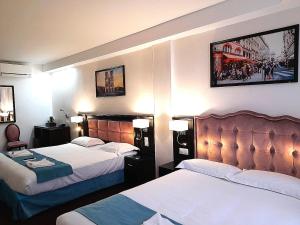塞纳河畔伊夫里HOTEL ROYAL Paris Ivry的酒店客房设有两张床和两盏灯。
