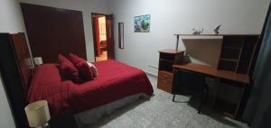 帕潘特拉德奧拉特Cómodo departamento的一间卧室配有红色的床和一张书桌