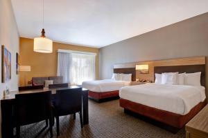 圆石城TownePlace Suites by Marriott Austin Round Rock的酒店客房配有两张床和一张书桌