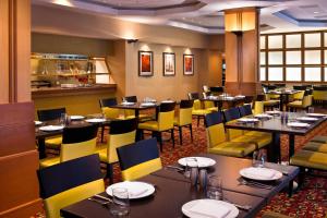 唐纳斯格罗夫Hampton Inn & Suites Downers Grove Chicago的用餐室配有桌子和黄色椅子