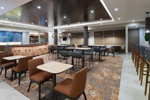 达拉斯SpringHill Suites by Marriott Dallas Richardson/University Area的一间带桌椅的餐厅和一间酒吧