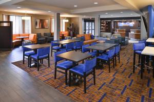 苏万尼亚特兰大苏万尼万怡酒店的一间配备有桌子和蓝色椅子的用餐室