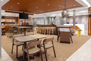 博福特SpringHill Suites by Marriott Beaufort的一间带桌椅的餐厅和一间酒吧