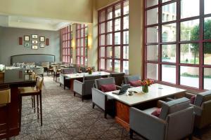 亚特兰大Atlanta Marriott Suites Midtown的餐厅设有桌椅和窗户。