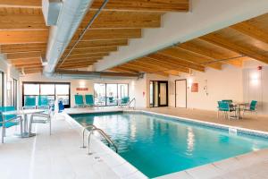 曼斯费尔德TownePlace Suites by Marriott Ontario-Mansfield的一个带蓝色椅子和桌子的游泳池