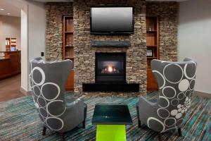 哈蒂斯堡Residence Inn by Marriott Hattiesburg的客厅配有两把椅子和壁炉