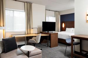 珀尔Residence Inn by Marriott Jackson Airport, Pearl的配有一张床和一张书桌的酒店客房