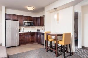 奥斯汀奥斯汀机场原住客栈酒店的厨房配有桌椅和冰箱。