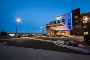 布赖顿Fairfield Inn & Suites by Marriott Denver Northeast/Brighton的晚上在酒店前面的一个停车场