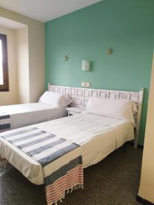 罗列特海岸圣安娜旅舍的蓝色墙壁客房的两张床