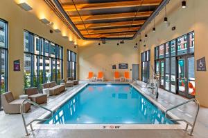 哥伦布Aloft Columbus Easton的酒店大堂的游泳池,设有椅子和游泳池
