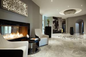 柏林傲途格精选酒店旗下斯坦普朗兹酒店的客厅设有壁炉和白色椅子