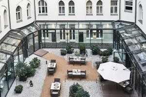 柏林傲途格精选酒店旗下斯坦普朗兹酒店的享有带桌子和遮阳伞的天井的顶部景致。