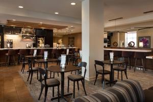 丹佛丹佛机场万怡酒店的一间带桌椅的餐厅和一间酒吧