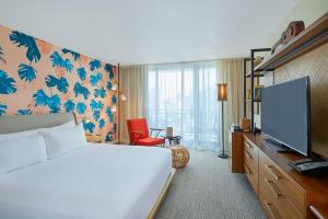 檀香山雷洛傲途格精选酒店的配有一张床和一台平面电视的酒店客房